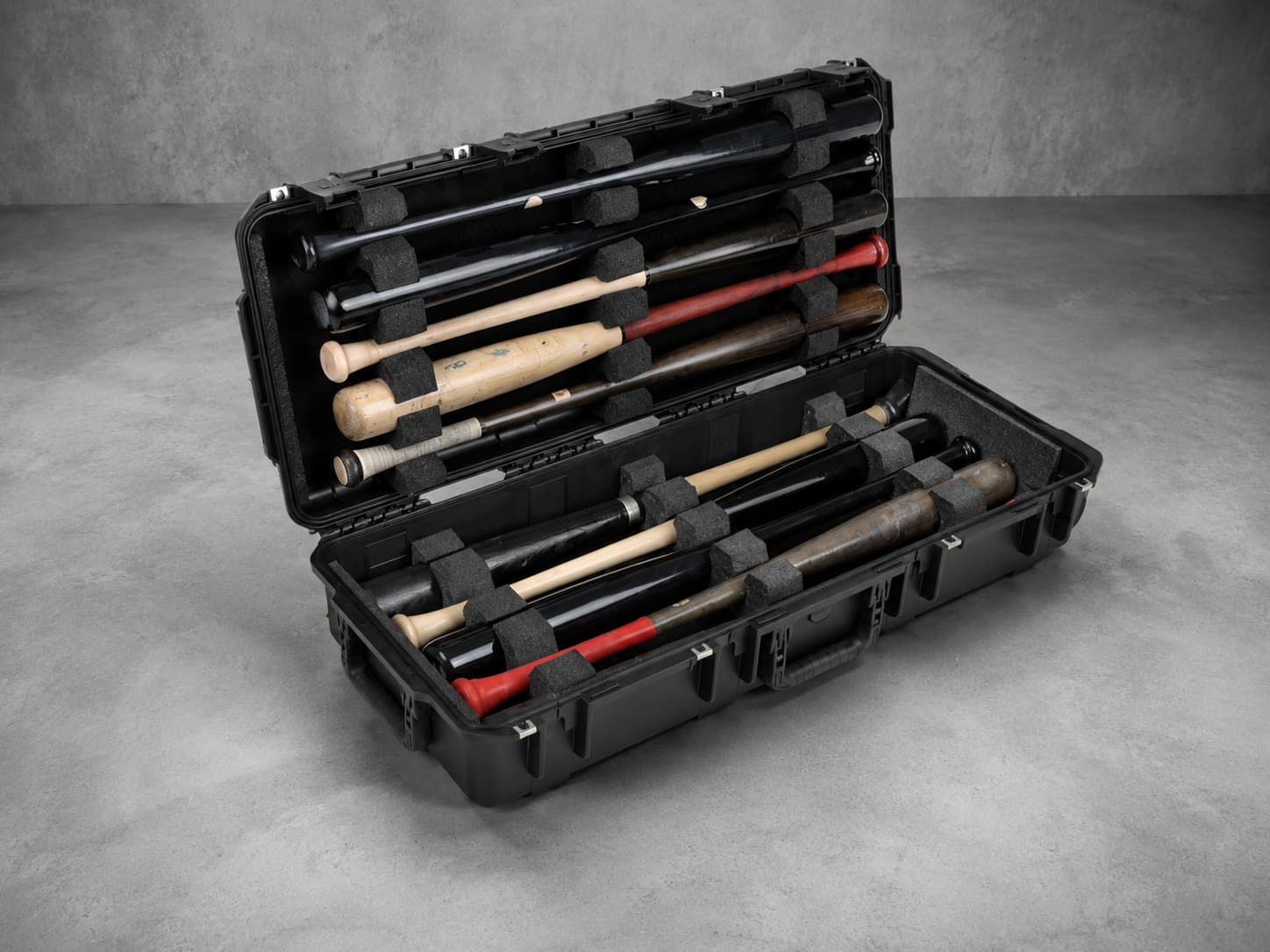 A long protective case with custom foam inserts holding a set of baseball bats