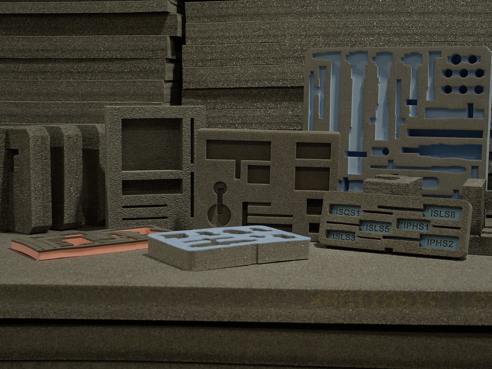 An arrangement of custom-cut foam inserts and components on the shop bench