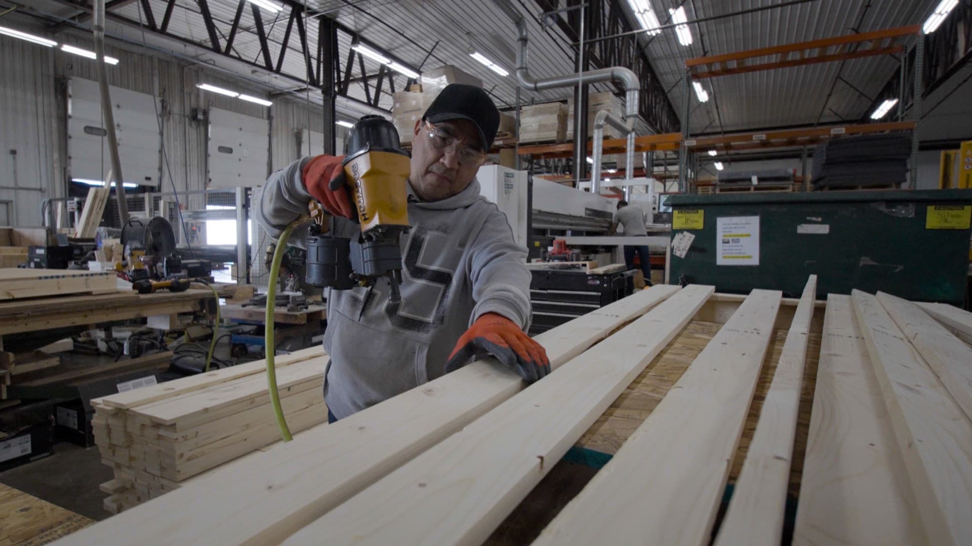 A FoamCraft craftsman assembling a wood crate with a pneumatic nailer